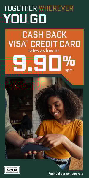 African American woman wearing yellow shirt paying man in apron using credit card